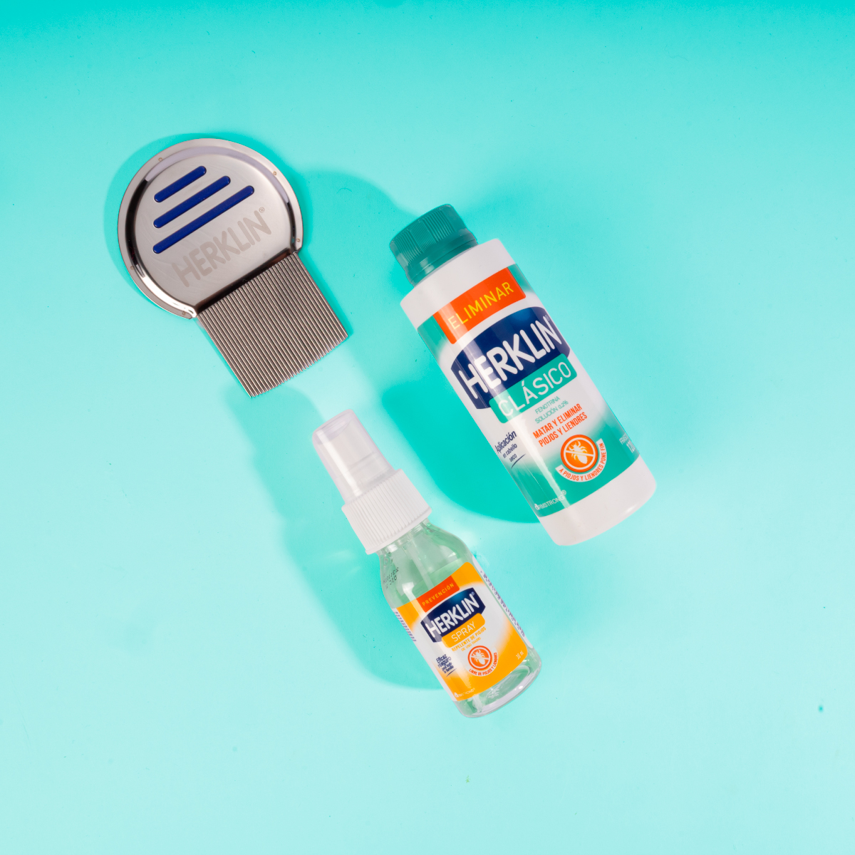 Contenido del Kit Antipiojos Herklin sobre fondo verde.