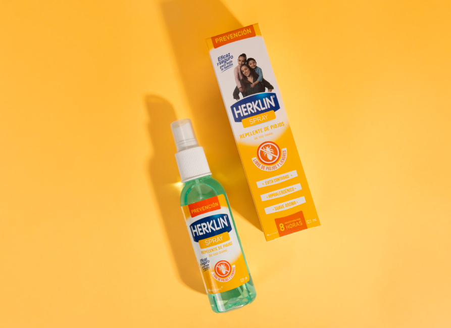 Herklin Spray Prevención y su empaque sobre fondo ámbar.