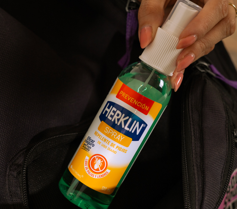 El frasco de Herklin Spray guardado en una mochila escolar.